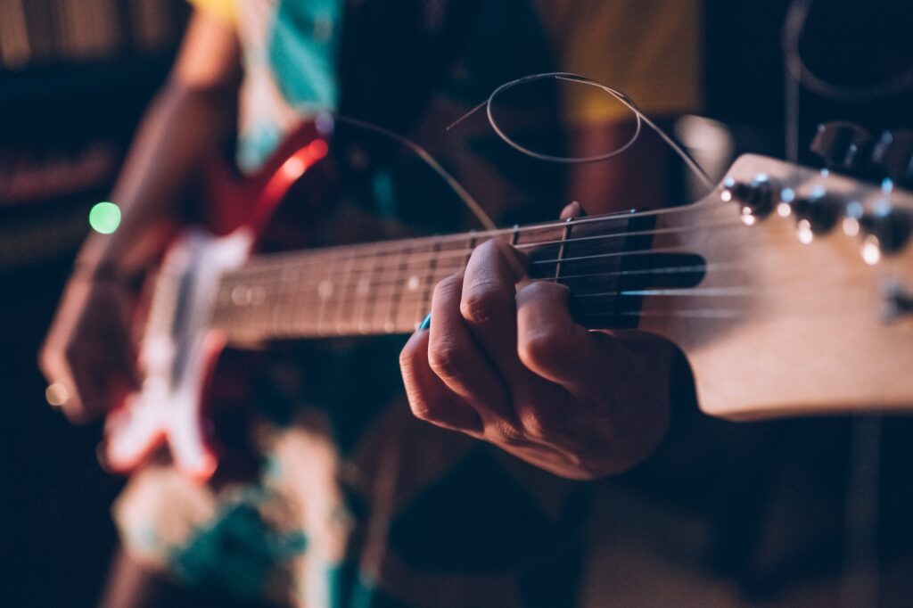 Close up young woman musician playing electric guitar